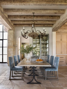 Custom dining room table with chandelier and antique wood beams