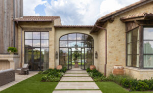 custom home with white stone and metal front arch doorway